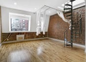 Thumbnail 13 of 17 - A room with a spiral staircase and a window overlooking a cityscape.