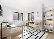 Thumbnail 13 of 56 - A white bedroom with a bed, chair, and shelves.
