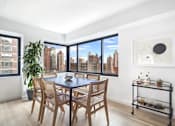 Thumbnail 15 of 56 - A dining room with a table and chairs and a view of the city.