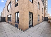 Thumbnail 40 of 56 - A modern brick building with a flat roof and large windows.