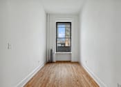 Thumbnail 5 of 9 - A room with a window and wooden floors.