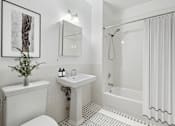 Thumbnail 6 of 9 - A white bathroom with a sink, toilet, and bathtub.