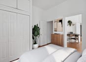 Thumbnail 5 of 11 - A white bedroom with a large bed and a plant in a white pot.
