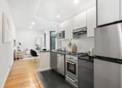 Thumbnail 10 of 18 - A modern kitchen with stainless steel appliances and wooden flooring.