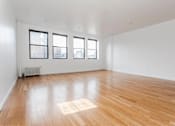 Thumbnail 5 of 19 - A room with wooden flooring and three windows.
