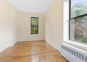 Thumbnail 13 of 18 - Empty room with wooden floor and a window.