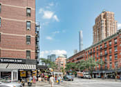 Thumbnail 15 of 18 - A street view of a city with a Kitchen & Bar on the corner.