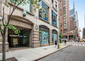 Thumbnail 17 of 18 - A street view of a city with a building that has a green sign on it.