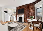 Thumbnail 3 of 18 - A living room with a fireplace and a television on the wall.