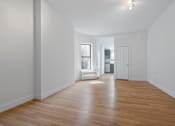 Thumbnail 7 of 18 - A room with wooden floors and white walls.