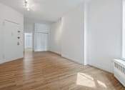 Thumbnail 9 of 18 - A room with wooden floors and white walls.