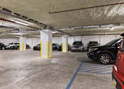 Thumbnail 17 of 22 - A parking garage with cars parked in it.