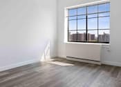 Thumbnail 2 of 22 - A room with a large window overlooking a cityscape.