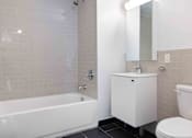 Thumbnail 4 of 22 - A white bathroom with a tub, toilet, and sink.