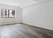 Thumbnail 5 of 22 - A room with a window and wooden flooring.