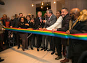 Thumbnail 5 of 9 - A group of people are gathered around a ribbon at a ribbon-cutting ceremony.