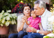 Thumbnail 22 of 28 - Lifestyle photo of grandparents blowing bubbles with grandchild at Oaks at Pompano, Pompano Beach, FL
