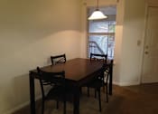 Thumbnail 10 of 28 - A brown wooden dining table with four chairs.