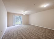 Thumbnail 21 of 21 - an empty living room with carpet and a sliding glass door