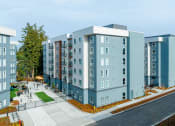 Thumbnail 4 of 22 - a rendering of a blue and gray apartment building with a sidewalk in front of it at QUINN BY VINTAGE, Shoreline, Washington