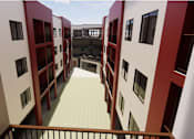 Thumbnail 7 of 7 - A balcony with a railing is surrounded by red and white buildings at Vintage at Lockwood Apartments, California, 93036