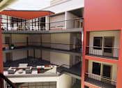 Thumbnail 6 of 7 - A red and white building with a balcony and a staircase at Vintage at Lockwood Apartments, California