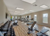 Thumbnail 29 of 48 - New Apartments in Airway Heights-Salish Flats-Fitness Center with Equipment, Hardwood Style Flooring, a TV, and Large Windows at Salish Flats APARTMENTS, Airway Heights, WA 99001