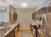Thumbnail 32 of 48 - Kitchen with Stainless Steel Appliances, Hardwood Style Flooring, Wood Cabinets, and Overhead Lighting at Salish Flats APARTMENTS, Airway Heights