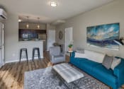 Thumbnail 37 of 48 - Wood-Style Flooring with Comfortable Couch and Blue Wall Art at Salish Flats APARTMENTS, Airway Heights, WA
