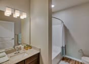 Thumbnail 38 of 48 - New Apartments in Airway Heights - Salish Flats - Bathroom with Seperate Shower Area, Vanity Mirror, and Wood-Style Floors at Salish Flats APARTMENTS, Washington