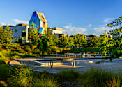 Thumbnail 74 of 81 - a park with a fountain and buildings in the background