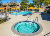 Thumbnail 6 of 19 - Pool with lounge chairs and umbrellas at THE EDGE Apartments, DAVIS