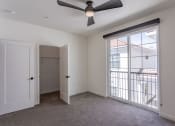 Thumbnail 33 of 41 - a bedroom with a large window and a ceiling fan at THE ANGELINO, Sacramento, 95819