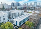 Thumbnail 13 of 33 - Downtown Sacramento, CA Apartments for Rent - Mod at Midtown - Aerial View of Property Exterior, with Surrounding Trees, Street, and City Views