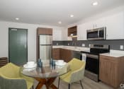 Thumbnail 10 of 33 - a kitchen and dining room with a table and chairs at THE MOD AT MIDTOWN Apartments, SACRAMENTO