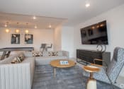 Thumbnail 2 of 33 - a living room with couches and a table and a television at THE MOD AT MIDTOWN Apartments, California