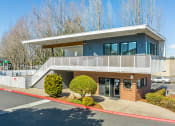 Thumbnail 2 of 31 - a blue house with a balcony and a parking lot in front of it at Township Eastside, Oregon