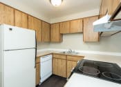Thumbnail 27 of 31 - Apartments in Gresham, OR- Township Eastside- Wood-Style Cabinets with Electric Stove and White Refrigerator at Township Eastside, Portland