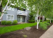 Thumbnail 20 of 31 - East Portland Apartments- Township Eastside- Landscaping with Building Balconies and Sidewalk Access at Township Eastside, Portland, OR