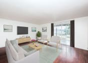 Thumbnail 5 of 31 - 2 BR Apartments in Gresham OR - Township Eastside - Living Room with Wood-Style Flooring, Couch, Chairs, Coffee Table, Area Rug, TV, and Sliding Glass Door at Township Eastside, Portland, 97236