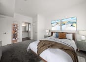 Thumbnail 5 of 9 - a bedroom with a bed and two paintings on the wall at Grand and Linden Family Apartments, South San Francisco