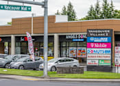 Thumbnail 34 of 37 - A parking lot with cars and a building with a sign that says Vancouver Mall.at Vancouver Mall Apartments, Vancouver