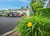 Thumbnail 20 of 37 - A parking lot with cars and a building in the background.at Vancouver Mall Apartments, Washington