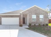 Thumbnail 21 of 32 - a small brick house with a white garage door