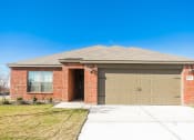 Thumbnail 19 of 33 - a brick house with a brown garage door