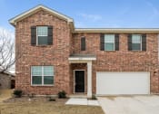 Thumbnail 1 of 32 - Homes in Haslet TX - Willow Springs - Brick Home Exterior with White Trim, Windows, and Brown Shutters, Manicured Lawns, a Driveway and Garage