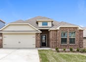 Thumbnail 8 of 23 - A house with a garage and a brick facade.