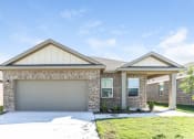 Thumbnail 17 of 32 - the front of a brick house with a garage door