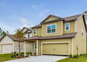 Thumbnail 1 of 56 - A two-story house with a garage and a driveway.