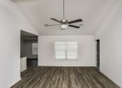 Thumbnail 8 of 33 - Newark TX Pet-Friendly Homes for Rent - Chisholm Springs - Unfurnished Living Room with White Walls, a Ceiling Fan, Wood-Style Flooring, and a Large Window